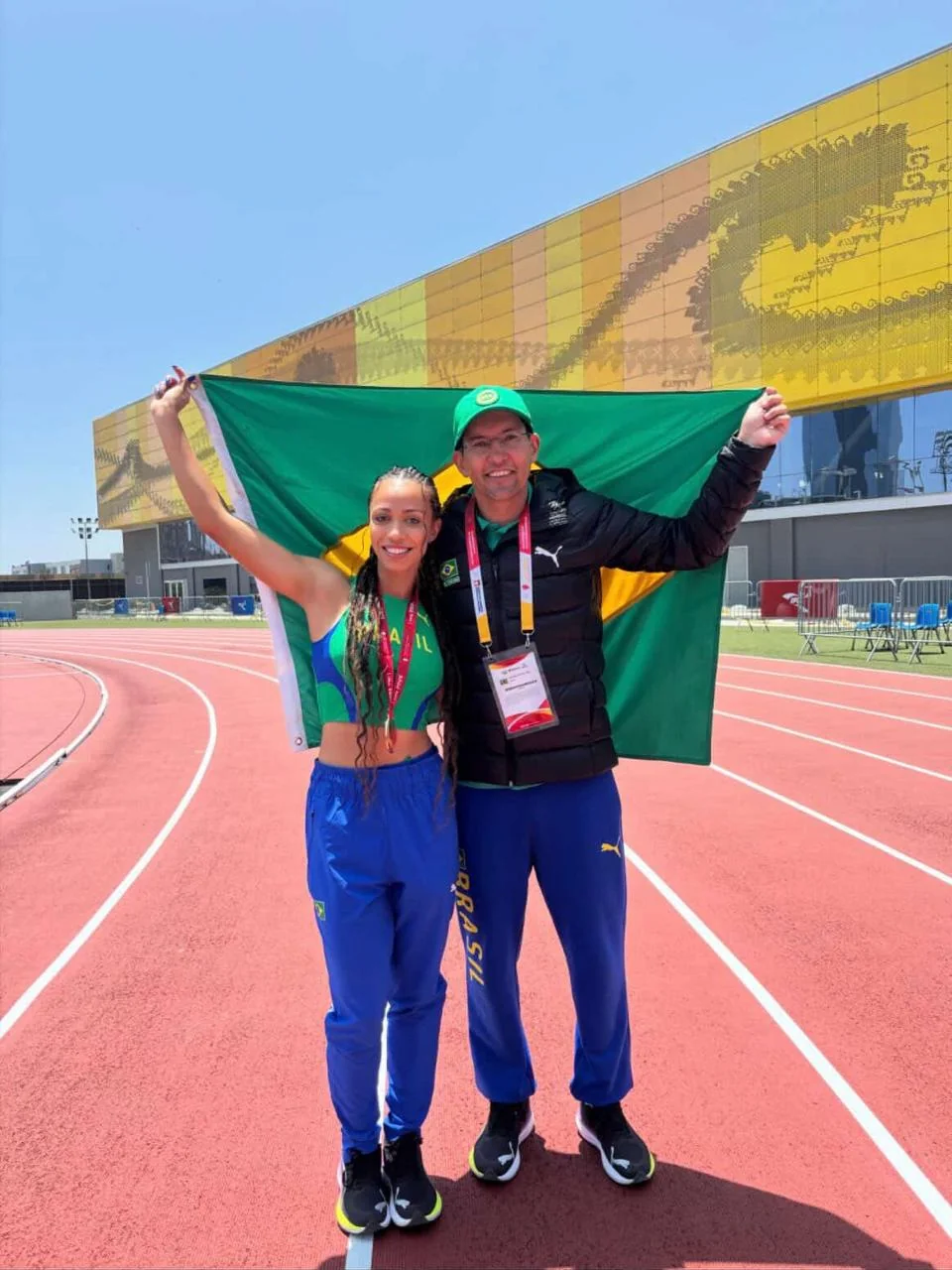 Alex Lopes e atleta brasileira celebrando com a bandeira do Brasil