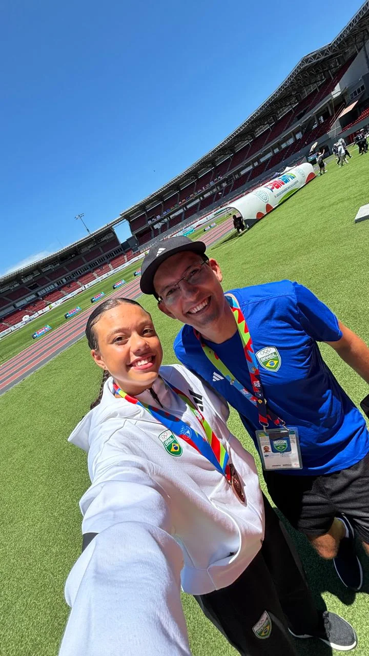 Alex Lopes com atleta brasileira em estádio de atletismo