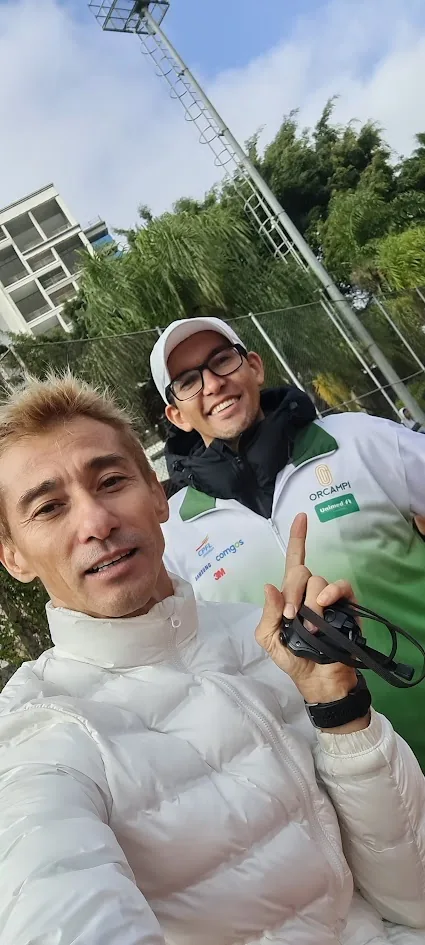 Alex com parceiro técnico em uma pista de atletismo